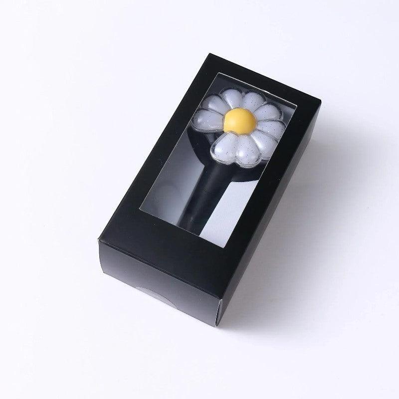 Lightstick Shop G-DRAGON Day-G Mini Lightstick Keychain, a compact, flower-shaped light with a yellow center and white petals, presented in a black box.