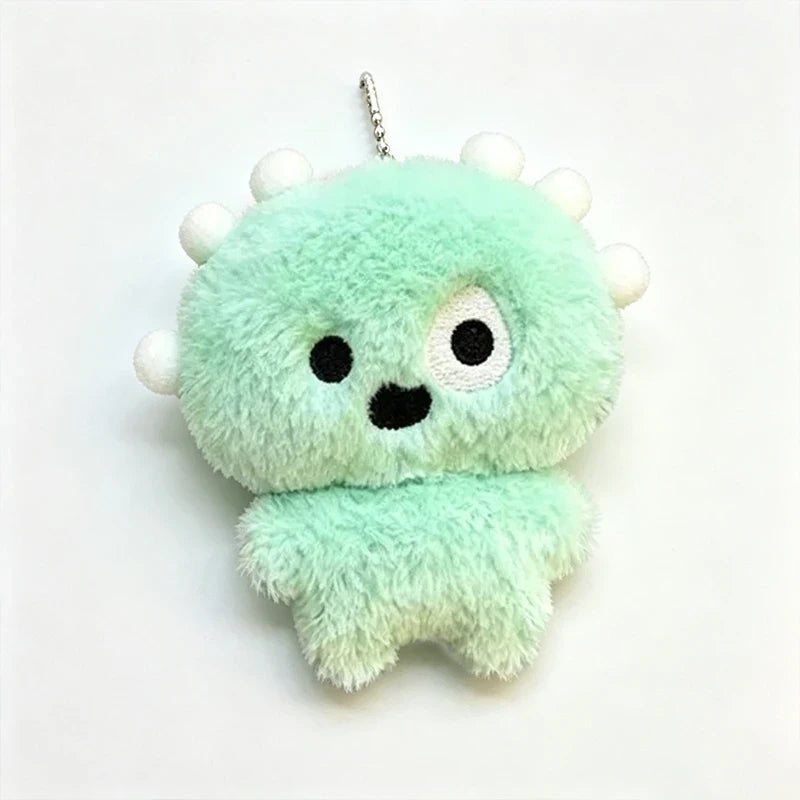 Green plush monster keychain with white pom-poms and a metal ball chain