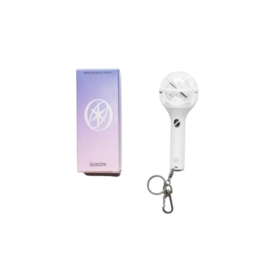 KATSEYE mini lightstick keyring with a white handle and clear globe top, next to its purple and pink gradient box.