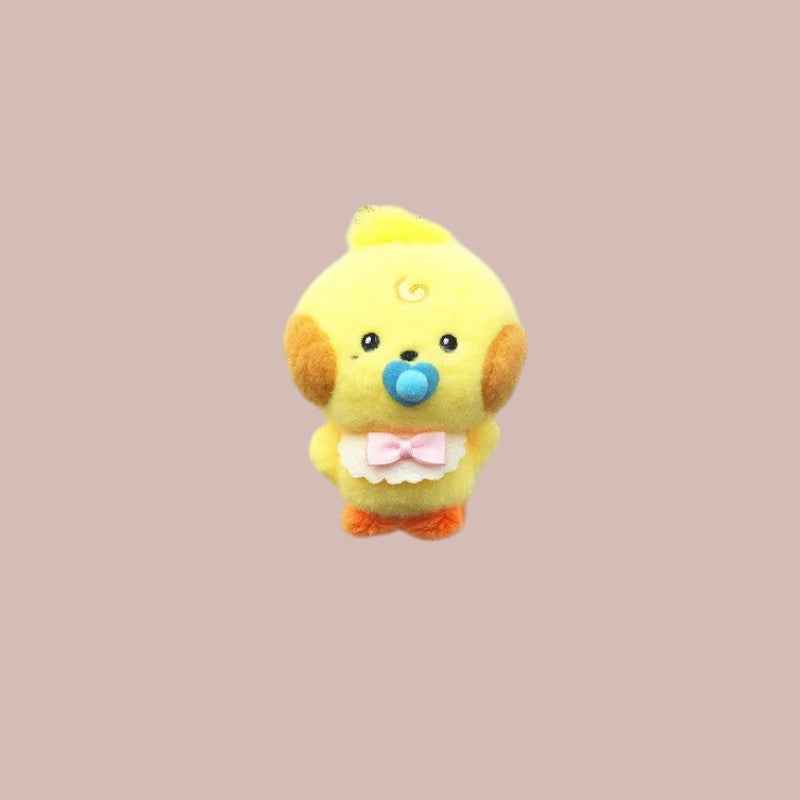 Lightstick Shop Zeroni yellow plush mascot doll with blue pacifier and pink bow bib, inspired by ZeroBaseOne.